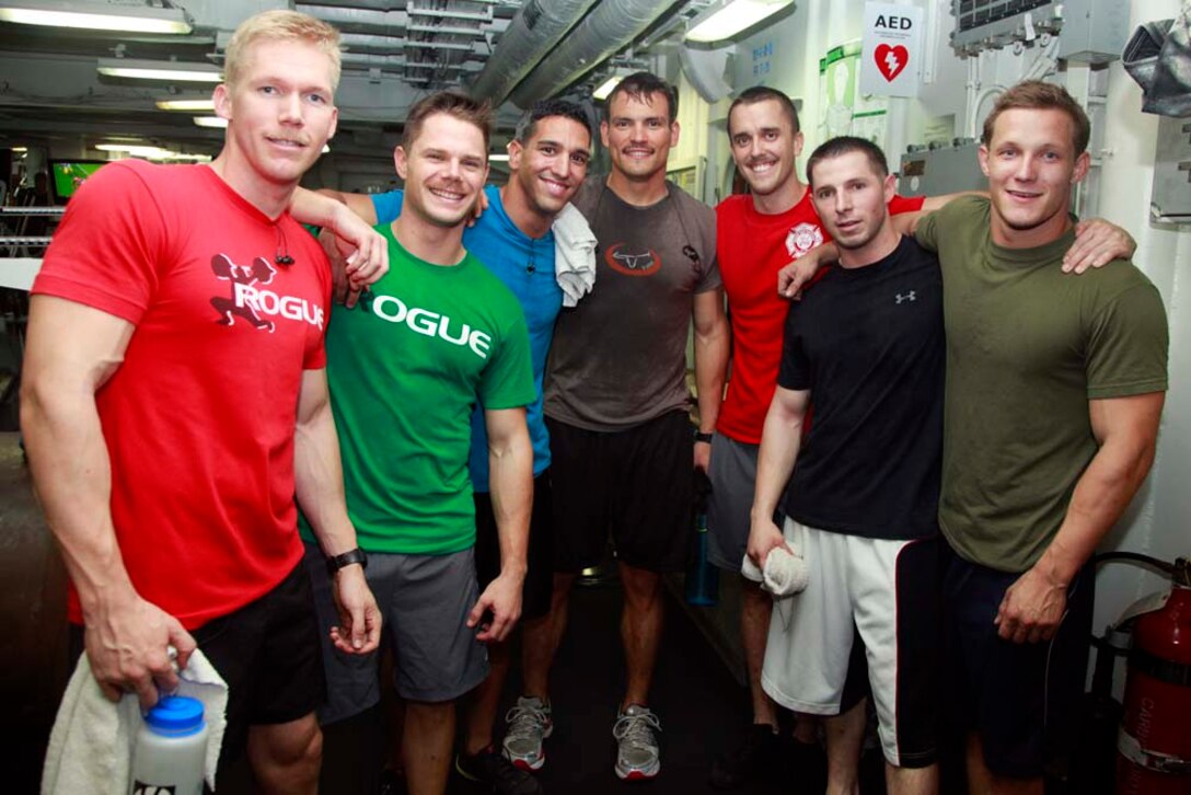 Marines with Marine Medium Helicopter Squadron 364 (Rein.), 15th Marine Expeditionary Unit, take a moment to enjoy their recent victory, accruing 538 pull-ups during the Campbell Cup Pull-Up Challenge in the gym of the USS Peleliu, Nov. 24. Marines and sailors of the 15th Marine Expeditionary Unit and Peleliu Amphibious Ready Group worked in teams of seven to see who could do the most pull-ups in ten minutes.  The 15th MEU is deployed as part of the Peleliu Amphibious Ready Group as a U.S. Central Command theater reserve force, providing support for maritime security operations and theater security cooperation efforts in the U.S. 5th Fleet area of responsibility. (U.S. Marine Corps photo by Cpl. John Robbart III/Released)