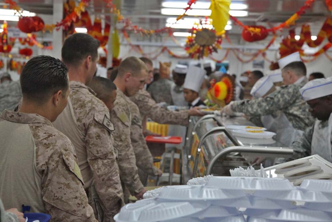 Marines assigned to the 15th Marine Expeditionary Unit take a break from training to enjoy a Thanksgiving holiday meal at Camp Buehring, Kuwait, during Exercise Eager Mace 13, Nov. 22. The U.S. Navy and Marine Corps are participating in the bilateral training exercise with the Kuwait Armed Forces to expand levels of cooperation, enhance mutual maritime capabilities and promote long-term regional stability and interoperability between U.S. forces and regional partners. The 15th MEU is deployed as part of the Peleliu Amphibious Ready Group as a U.S. Central Command theater reserve force, providing support for maritime security operations and theater security cooperation efforts in the U.S. 5th Fleet area of responsibility. (U.S. Marine Corps photo by Cpl. Timothy R. Childers/Released)
