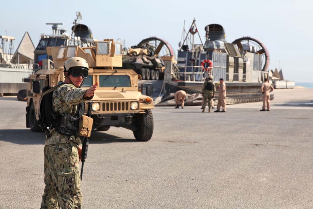 A sailor directs a Humvee off a landing craft air cushion at Camp Patriot, Kuwait, beginning Exercise Eager Mace 13, Nov. 8. The U.S. Navy and Marine Corps are participating in the bilateral training exercise with the Kuwait Armed Forces to expand levels of cooperation, enhance mutual maritime capabilities and promote long-term regional stability and interoperability between U.S. forces and regional partners. The 15th MEU is deployed as part of the Peleliu Amphibious Ready Group as a U.S. Central Command theater reserve force, providing support for maritime security operations and theater security cooperation efforts in the U.S. 5th Fleet area of responsibility. (U.S. Marine Corps photo by Cpl. Timothy Childers/Released)

 