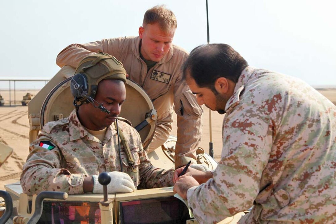 Sergeant Benjamin C. Bohn, tank master gunner, Tanks Platoon, India Company, Battalion Landing Team 3/5, 15th Marine Expeditionary Unit, helps the tank crew with the Kuwait Armed Forces adjust their aim at a live-fire range near Camp Buehring during  Exercise Eager Mace 13, Nov. 13. The U.S. Navy and Marine Corps are participating in the bilateral training exercise with the Kuwait Armed Forces to expand levels of cooperation, enhance mutual maritime capabilities and promote long-term regional stability and interoperability between U.S. forces and regional partners. The 15th MEU is deployed as part of the Peleliu Amphibious Ready Group as a U.S. Central Command theater reserve force, providing support for maritime security operations and theater security cooperation efforts in the U.S. 5th Fleet area of responsibility. (U.S. Marine Corps photo by Cpl. Timothy Childers/Released)