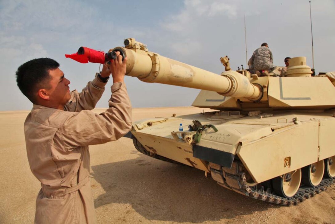Lance Corporal Ruben Reyes, tank crewman, Tanks Platoon, India Company, Battalion Landing Team 3/5, 15th Marine Expeditionary Unit, inserts a bore sight into the barrel of an M1A2 Abrams tank at a live-fire range near Camp Buehring, during Exercise Eager Mace 13, Nov. 13. The U.S. Navy and Marine Corps are participating in the bilateral training exercise with the Kuwait Armed Forces to expand levels of cooperation, enhance mutual maritime capabilities and promote long-term regional stability and interoperability between U.S. forces and regional partners. The 15th MEU is deployed as part of the Peleliu Amphibious Ready Group as a U.S. Central Command theater reserve force, providing support for maritime security operations and theater security cooperation efforts in the U.S. 5th Fleet area of responsibility. (U.S. Marine Corps photo by Cpl. Timothy Childers/Released)