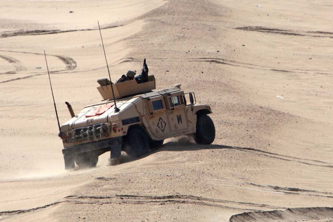 A humvee from Combined Anti-Armor Team 2, Weapons Company, Battalion Landing Team 3/5, 15th Marine Expeditionary Unit, drives across a sand dune, assaulting an objective alongside a U.S. Army tank team at a live-fire range near Camp Buehring, during Exercise Eager Mace 13, Nov. 14. Marines and soldiers were instructing members of the Kuwait Armed Forces how to assault and enemy force. The U.S. Navy and Marine Corps are participating in the bilateral training exercise with the Kuwait Armed Forces to expand levels of cooperation, enhance mutual maritime capabilities and promote long-term regional stability and interoperability between U.S. forces and regional partners. The 15th MEU is deployed as part of the Peleliu Amphibious Ready Group as a U.S. Central Command theater reserve force, providing support for maritime security operations and theater security cooperation efforts in the U.S. 5th Fleet area of responsibility. (U.S. Marine Corps photo by Cpl. Timothy Childers/Released)