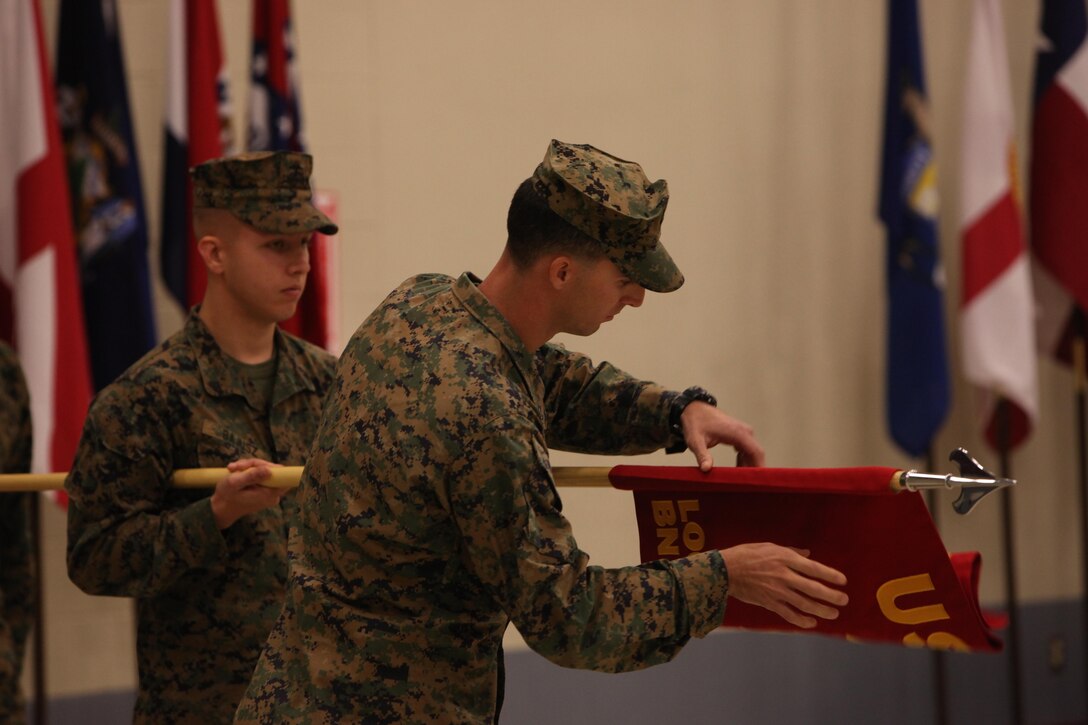 Captain Derek Ray, a logistics officer with the new Marine Special Operations Logistics Battalion, U.S. Marine Corps Forces, Special Operations Command, unfurls MSOLB's guidon during its activation ceremony aboard MARSOC headquarters, Camp Lejeune, NC, Nov. 15. Approximately 800 new Marines will arrive at MARSOC's new support components by 2016. (U.S. Marine Corps photo by Cpl. Kyle McNally/Released)