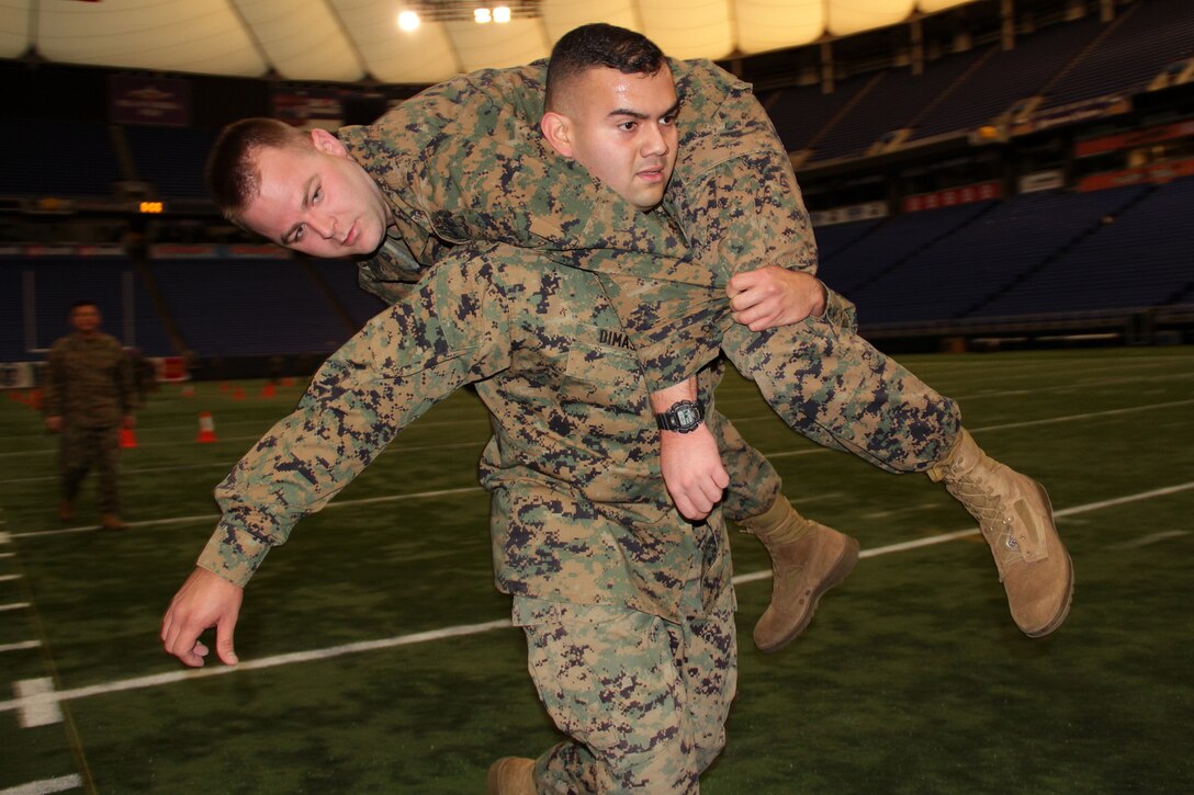 Sgt. Josue Dimas, 25, from Dallas, carries Sgt. Daniel Stromquist, 29, from Little Canada, Minn., during the maneuver under fire portion of his combat fitness test at the Metrodome on Nov. 21. Both Marines work out of the St. Cloud, Minn., recruiting office. For additional imagery from the event, visit www.facebook.com/rstwincities.