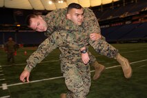Sgt. Josue Dimas, 25, from Dallas, carries Sgt. Daniel Stromquist, 29, from Little Canada, Minn., during the maneuver under fire portion of his combat fitness test at the Metrodome on Nov. 21. Both Marines work out of the St. Cloud, Minn., recruiting office. For additional imagery from the event, visit www.facebook.com/rstwincities.