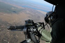 Lance Cpl. Joseph E. Miller, Marine Light Attack Helicopter 269 crew chief, 
prepares to fire a GUA-17 minigun during a training exercise in support of 
Marine Special Operations Command Nov. 28. 
