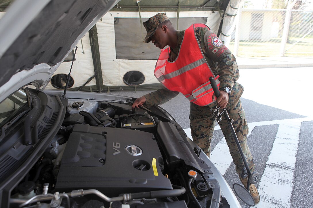 Lance Cpl. Montae R. Johnson performs a random vehicle inspection at gate 1 at Camp Hansen Nov. 8. Performing a random vehicle inspection is one way the interior guard ensures the security of the installation. The purpose of the interior guard is to preserve order, protect property and enforce regulations. 