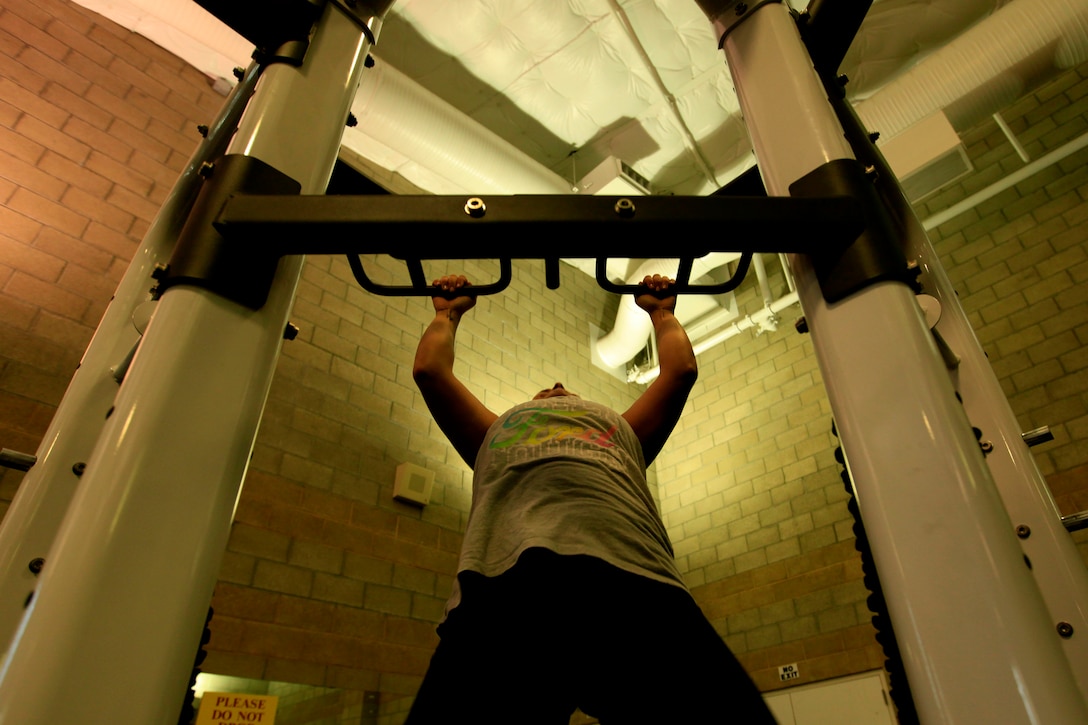 Cpl. Arianna Tufiariello, a Marine Corps Base Camp Pendleon postal clerk, performs pull-ups at the Paige Fieldhouse here Nov. 28. Tufiariello can currently perform eight, proper Marine Corps pull-ups and is fully prepared for the new physical fitness test standard. An All Marine Message was released, mandating female Marines must perform eight pull-ups to get the maximum score as part of the annual PFT beginning January 2014.