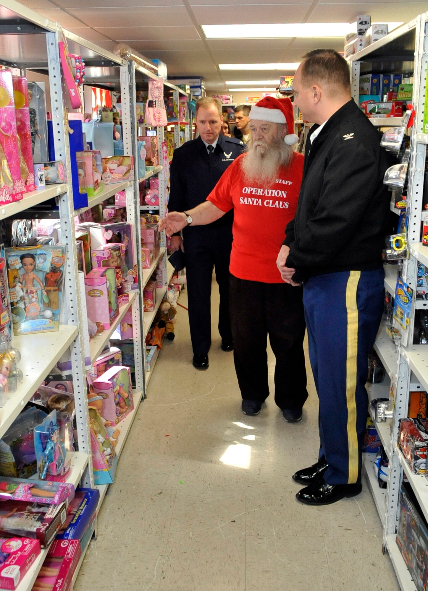 Army Col. Charles Coursey and Navy Capt. William Bullis, Joint Base McGuire-Dix-Lakehurst deputy commanders, and Col. John Wood, 87th Air Base Wing commander, receive a tour Vince Bowker, Operation Santa president, Nov. 26, 2012, at Operation Santa Headquarters 5343 Airfield Rd. here.  Operation Santa Claus is a year round center that collects new and good condition used toys for distribution during the month of December to military families in need of assistance. Bowker has been a member has been a member of Operation Santa Claus since 1994 and the organization president since 1999. (U.S. Air Force photo by Wayne Russell/Released)