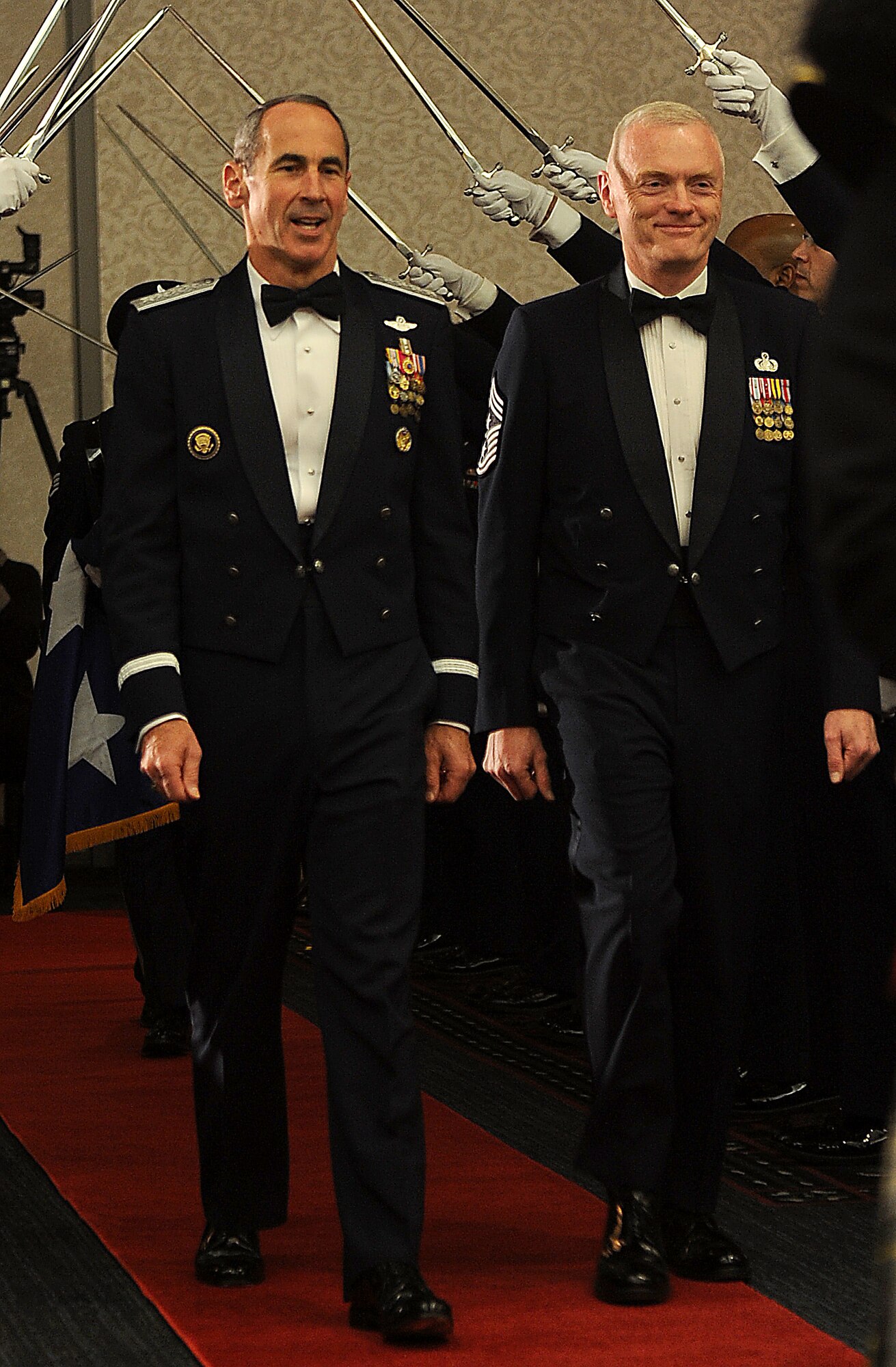 Gen. Raymond Johns Jr. Air Mobility Command commander, and Chief Master Sgt. Andy Kaiser, AMC command chief, walks through the sword cordon during the Order of the Sword ceremony Nov. 28, 2012.  An Order of the Sword is the highest honor enlisted Airmen can bestow upon a leader. (U.S. Air Force photo/Senior Airman Divine Cox)
