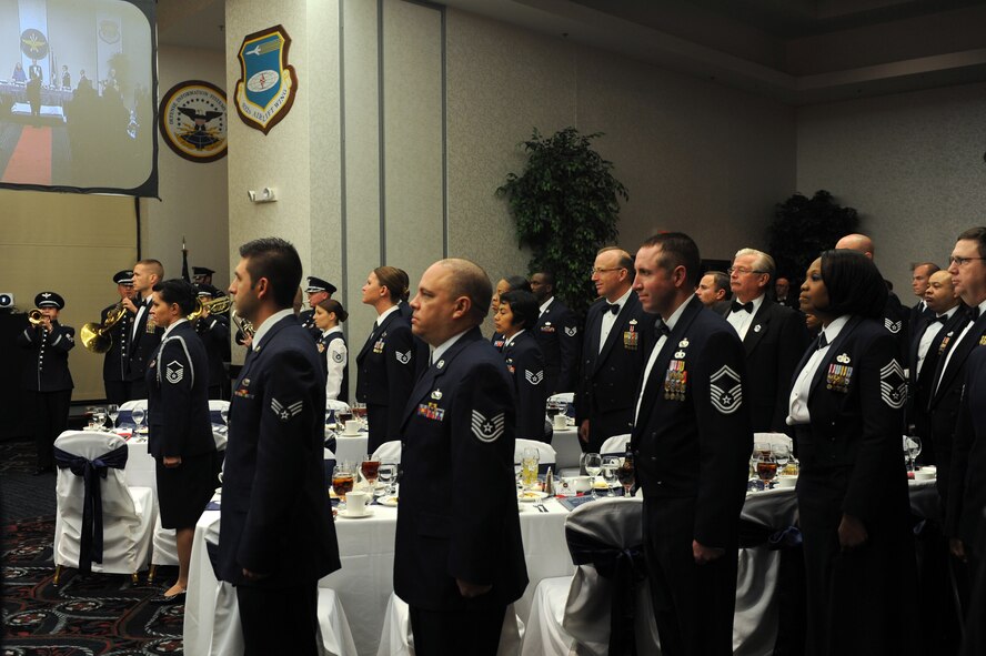 Attendees stand and pay honor to Gen. Raymond E. Johns, Air Mobility Command commander during the playing of Ruffles and Flourishes at the Order of the Sword ceremony on Nov. 28, 2012 at Scott Air Force Base, Ill. The Order of the Sword is the highest honor and tribute that Noncommissioned Officers can bestow upon an individual.(U.S. Air Force photo/Staff Sgt. Teresa M. Jennings)