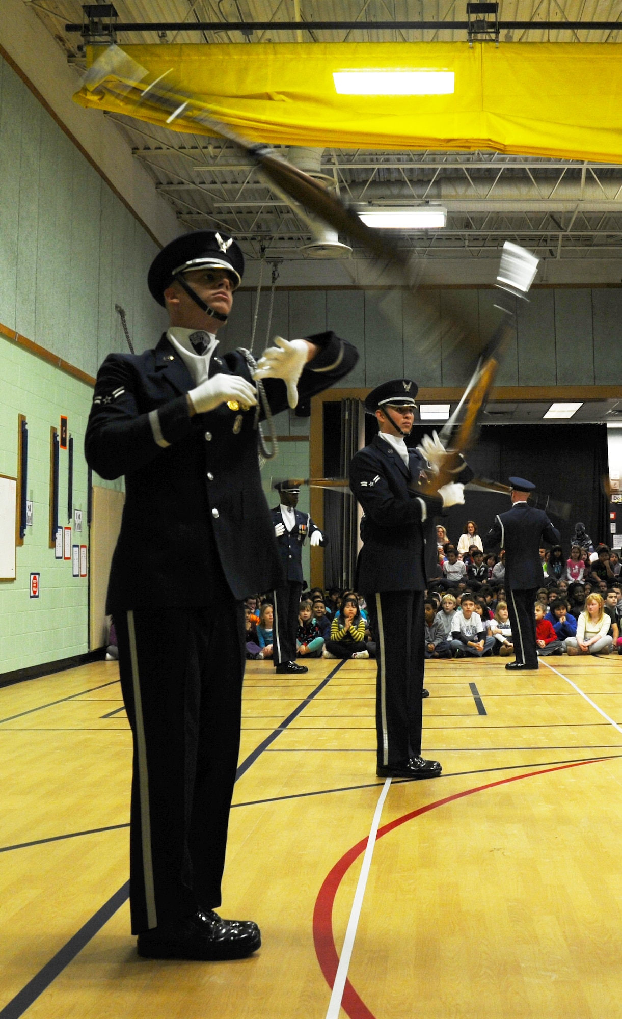 Members of the U.S. Air Force Honor Guard Drill Team toss their M-1 rifles during a performance at Belvedere Elementary School in Falls Church, Va., Nov. 26, 2012.   Inspiring patriotism and garnering interest in the U.S. Air Force are key aspects of the Drill Team mission.  (U.S. Air Force photo/Staff Sgt. Torey Griffith)