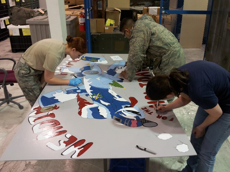 Reservists from the 442nd Fighter Wing work on a large holiday greeting card that will be displayed at Whiteman Air Force Base, Mo. The greeting card was an entry in a contest hosted by the 509th Force Support Squadron. The card took nearly 24 hours to complete with nearly a dozen volunteers' contributions. The 442nd Fighter Wing is an A-10 Thunderbolt II Air Force Reserve unit at Whiteman Air Force Base, Mo. (U.S. Air Force photo by Staff Sgt. Danielle Johnston/Released)