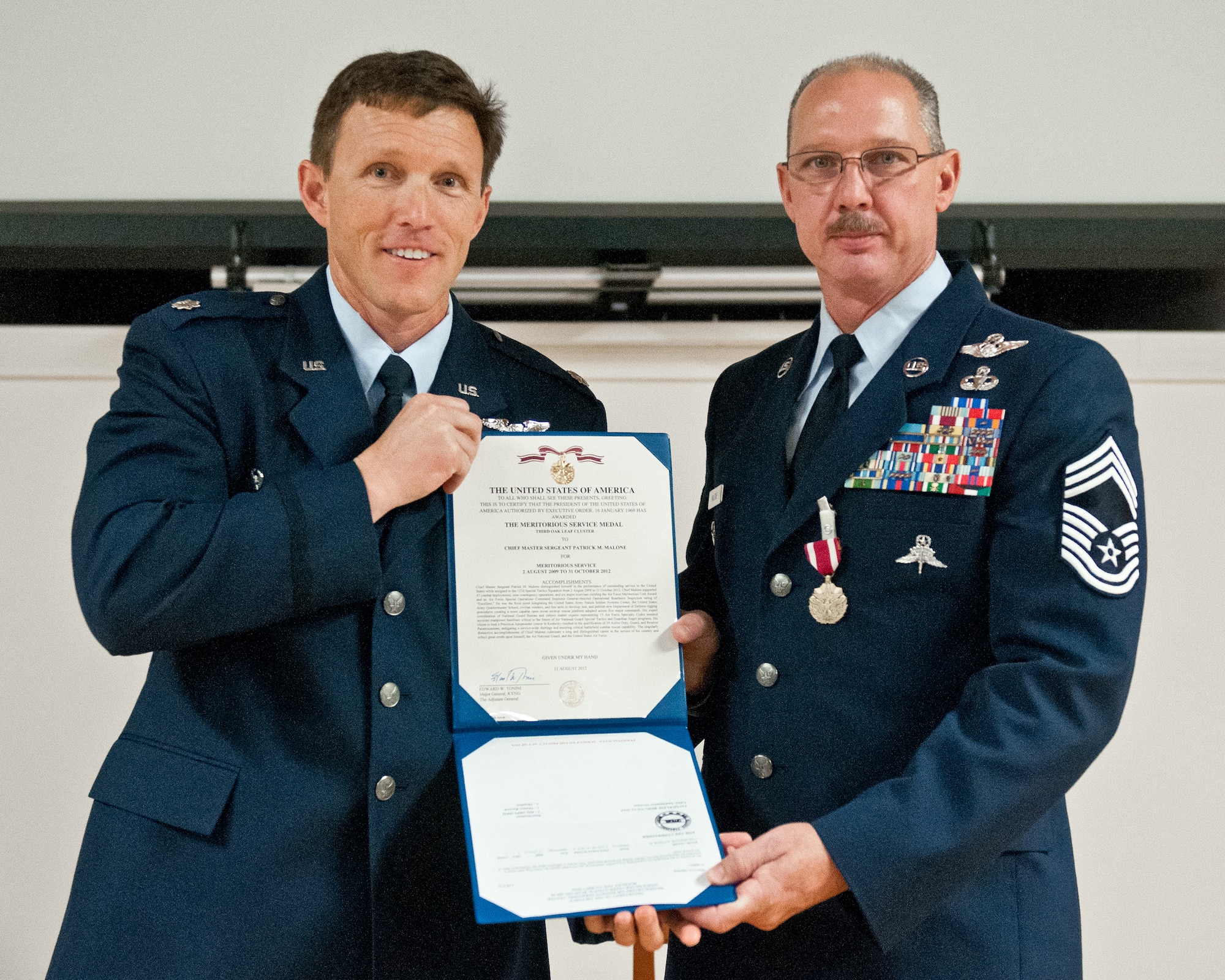 Lt. Col. Jeff Wilkinson, commander of the 123rd Special Tactics Squadron, presents Chief Master Sgt. Patrick Malone with a Meritorious Service Medal during Malone's retirement ceremony Oct. 20, 2012, at the Kentucky Air National Guard Base in Louisville, Ky. Malone served in the active-duty Air Force and Air National Guard for 30 years. (U.S. Air Force photo by Senior Airman Maxwell Rechel)