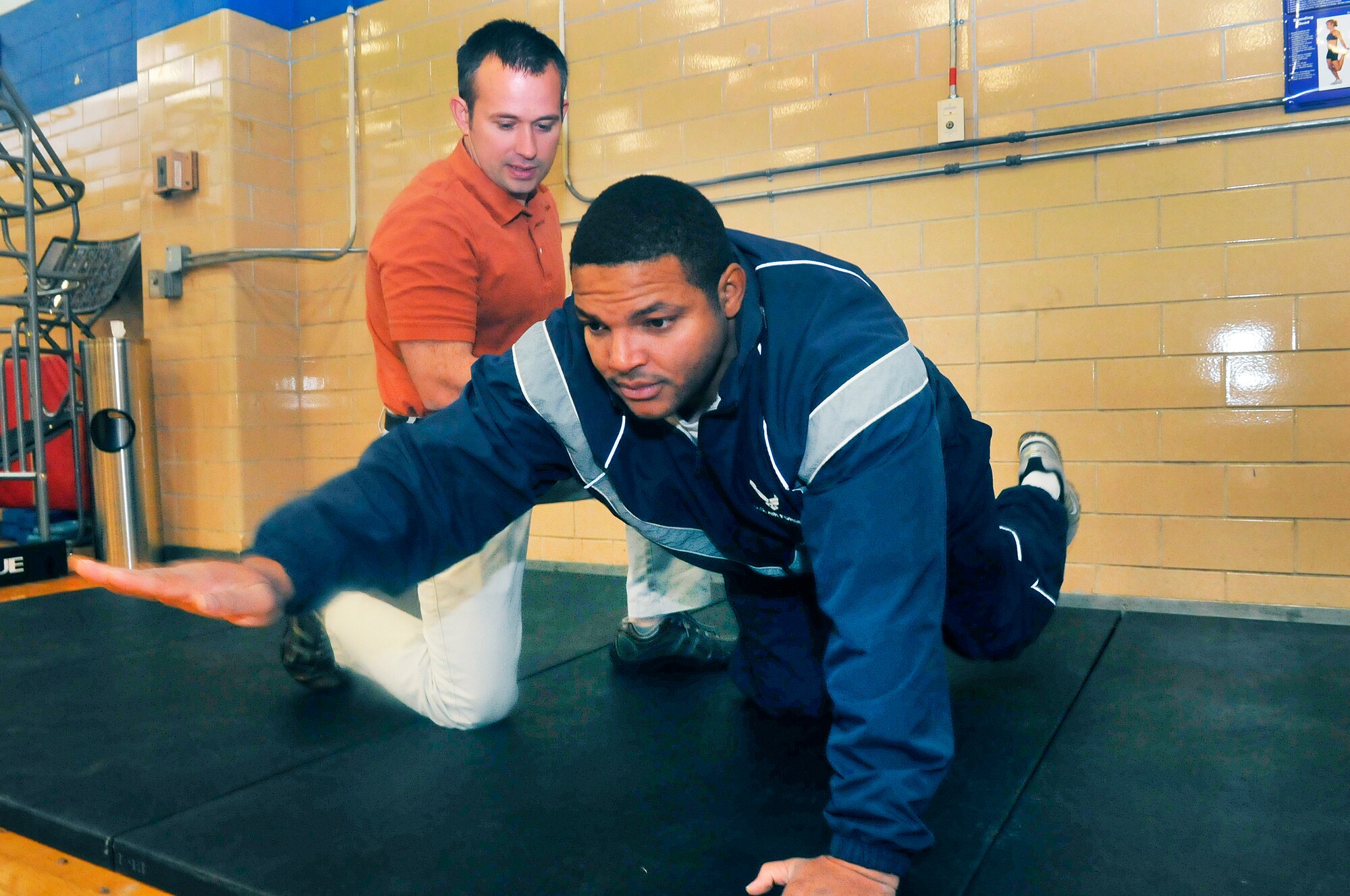 Greg Reynolds, Robins Health and Wellness Center exercise physiologist helps Tech. Sgt. Bruce Thompson, 78th Logistics Readiness Squadron, do a core strengthening exercise called the "birddog". (U. S. Air Force photo/Sue Sapp)