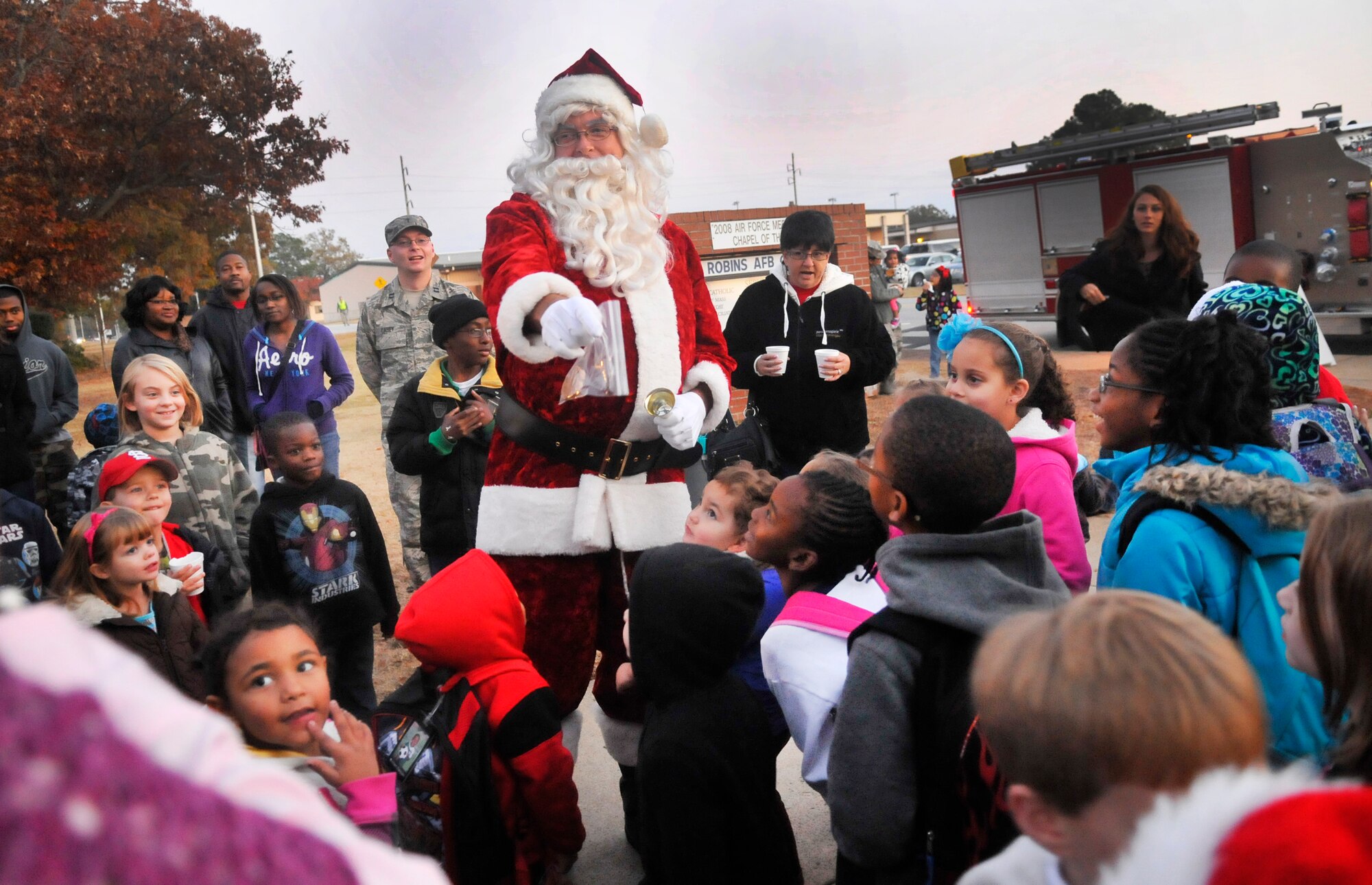 Santa delights the children by arriving on a firetruck at the Chapel Tree Lighting. (U. S. Air Force photo/Sue Sapp)