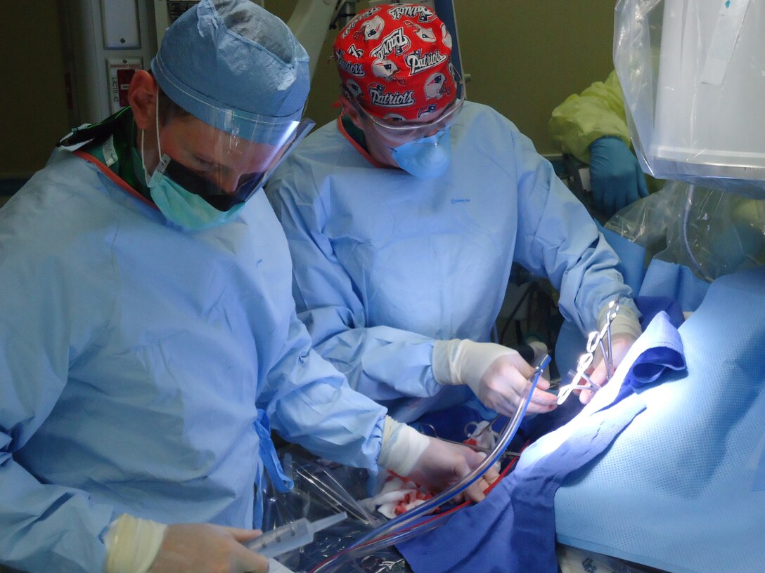 Lt. Col. (Dr.) Jeremy Cannon, right, and Dr. Jeremy Pamplin place a patient on extracorporeal membrane oxygenation, or ECMO, in September 2012 at San Antonio Military Medical Center in Texas. ECMO is a heart-lung bypass system that circulates blood through an external artificial lung and sends it back into the patient’s bloodstream. (Photo courtesy of U.S. Army Institute of Surgical Research)  

