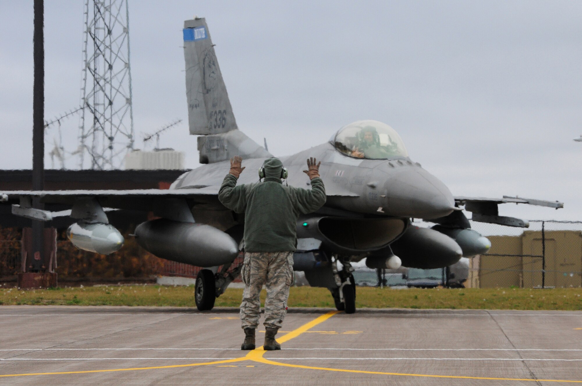 A 148th Fighter Wing crew chief directs a Block 50 F-16C Fighting Falcon aircraft to its parking spot at the Duluth Air National Guard Base after returning from Kandahar Airfield, Afghanistan, Oct. 22, 2012.  The 148th Fighter Wing, Minnesota Air National Guard, deployed approximately 300 airmen to Afghanistan in August, 2012 in support of Operation Enduring Freedom.  (National Guard photo by Tech. Sgt. Brett R. Ewald/ Released)