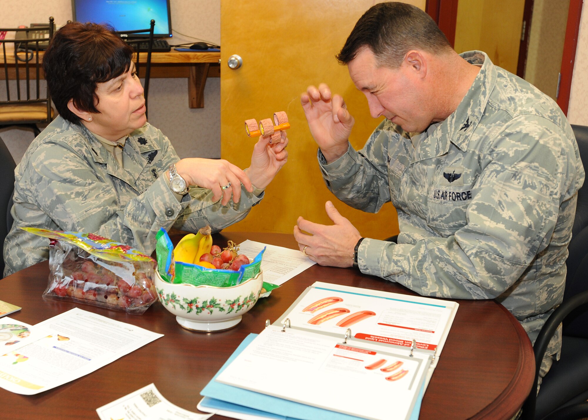 Lt. Col. Joanne Ruggeri, 319th Medical Group Health Care Integrator and Col. Tim Bush, 319th Air Base Wing commander, discuss how cholesterol affects the body at The Patient Education Center at the 319th MDG facility Nov. 26, 2012 on Grand Forks Air Force Base, N.D. The PEC provides self-management and self-care support that helps patients deal with the impacts illnesses may have on their life.  (U.S. Air Force photo/Airman 1st Class Xavier Navarro)