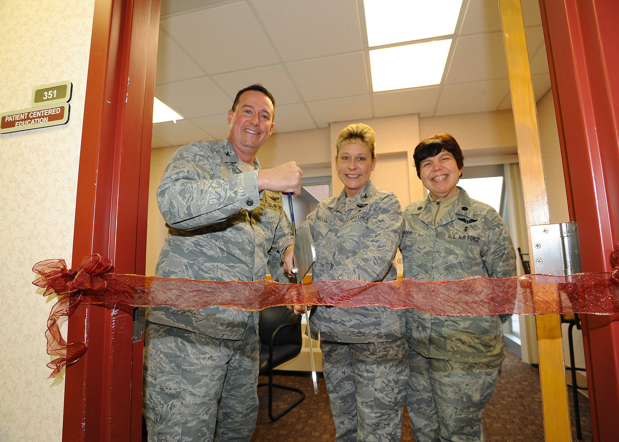Col. Tim Bush, 319th Air Base Wing commander and Col. Jane Denton, 319th Medical Group commander, accompanied by Lt. Col. Joanne Ruggeri, 319th MDG health care Integrator, cuts the ribbon to officially open The Patient Education Center inside the base medical facility Nov. 26, 2012 on Grand Forks Air Force Base, N.D.  The center provides self- management and self- care support that helps patients deal with the impacts their illness may have on their life. (U.S. Air Force photo/Airman 1st Class Xavier Navarro)