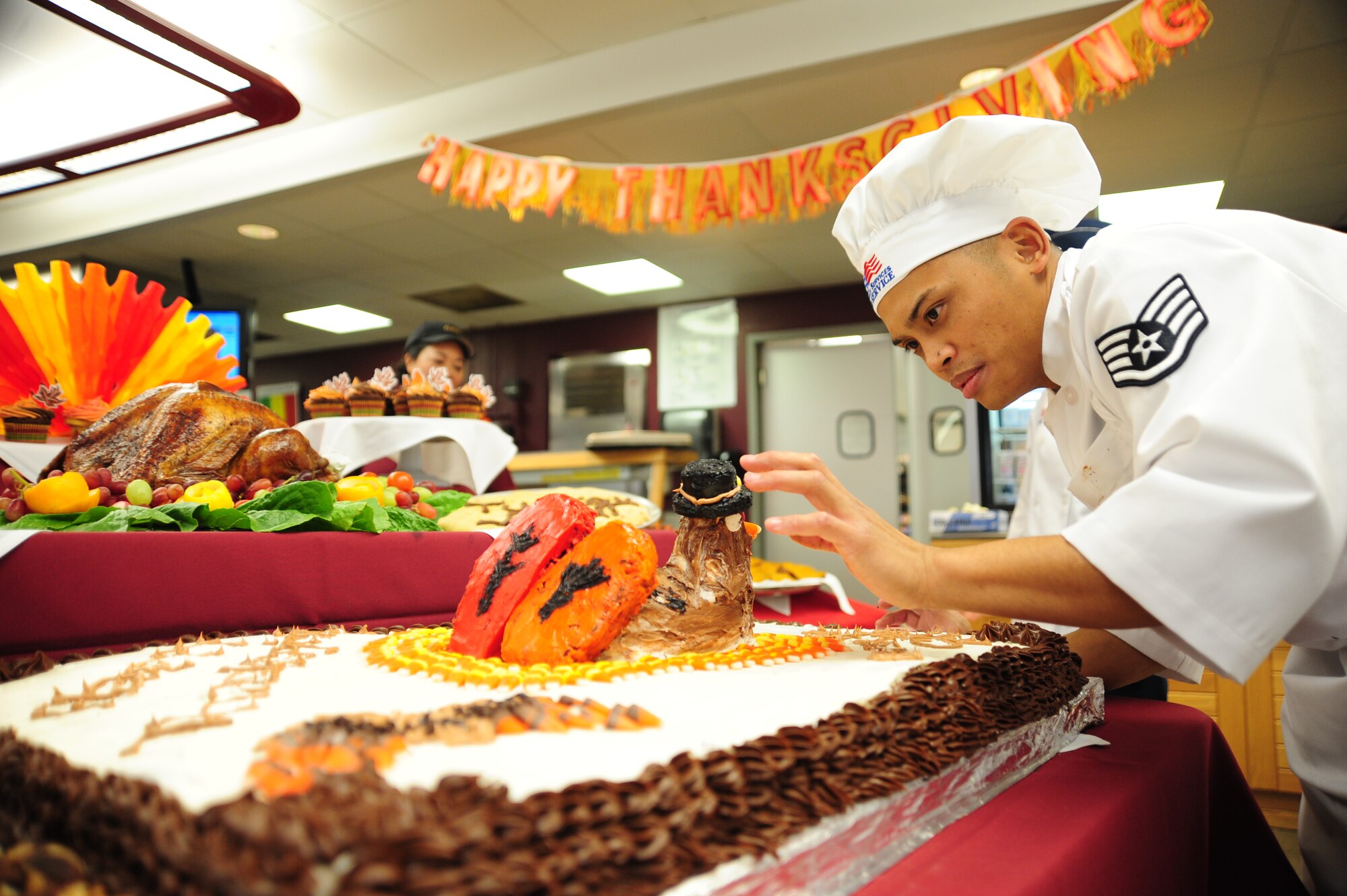 Staff Sgt. Jerry Calalang, 509th Force Support Squadron food services craftsman, applies the final touches to a Thanksgiving Day cake Nov. 22 at Whiteman Air Force Base, Mo. The dining facility served a special Thanksgiving Day meal to increase morale among Airmen and families on base. (U.S. Air Force photo/Senior Airman Nick Wilson) (Released)