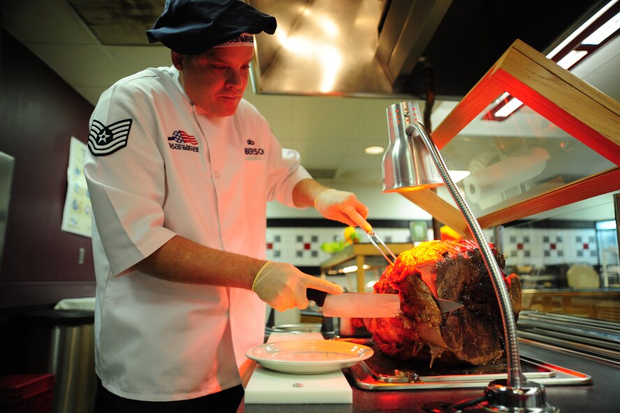 Tech. Sgt. David Giberson, 509th Force Support Squadron NCO in charge of food services, slices beef in preparation for a Thanksgiving Day meal in the dining facility Nov. 22 at Whiteman Air Force Base, Mo. Each year the dining facility hosts a Thanksgiving Day meal for Airmen and their families. This event boosts morale for Airmen that are working through the holidays and can’t make it home to their families. (U.S. Air Force photo/Senior Airman Nick Wilson) (Released)
