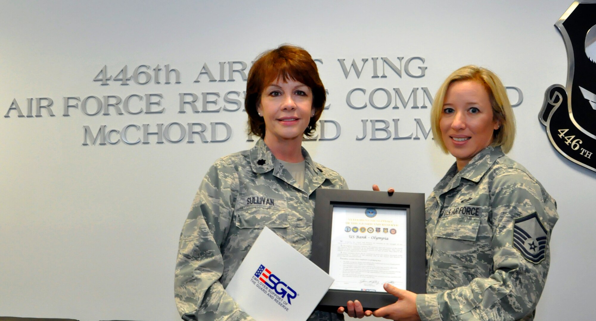 Lt. Col. Anna Sullivan, representing the Employer Support of the Guard and Reserve for Wash., presents the ESGR statement of support to Master Sgt. Dawn Kloos, the Olympia branch manager for U.S. Bank and a Reserve personnelist with the 446th Airlift Wing on McChord Field, Nov. 29. U.S. Bank has an initiative in place hiring more 1,000  veterans within a two-year time period. The Seattle metro region U.S. Bank locations were part of a pilot military leadership and development program placing veterans in leadership positions. The program was a success and is now branching out to six new locations across America. (U.S. Air Force Photo/Staff Sgt. Rachael Garneau)