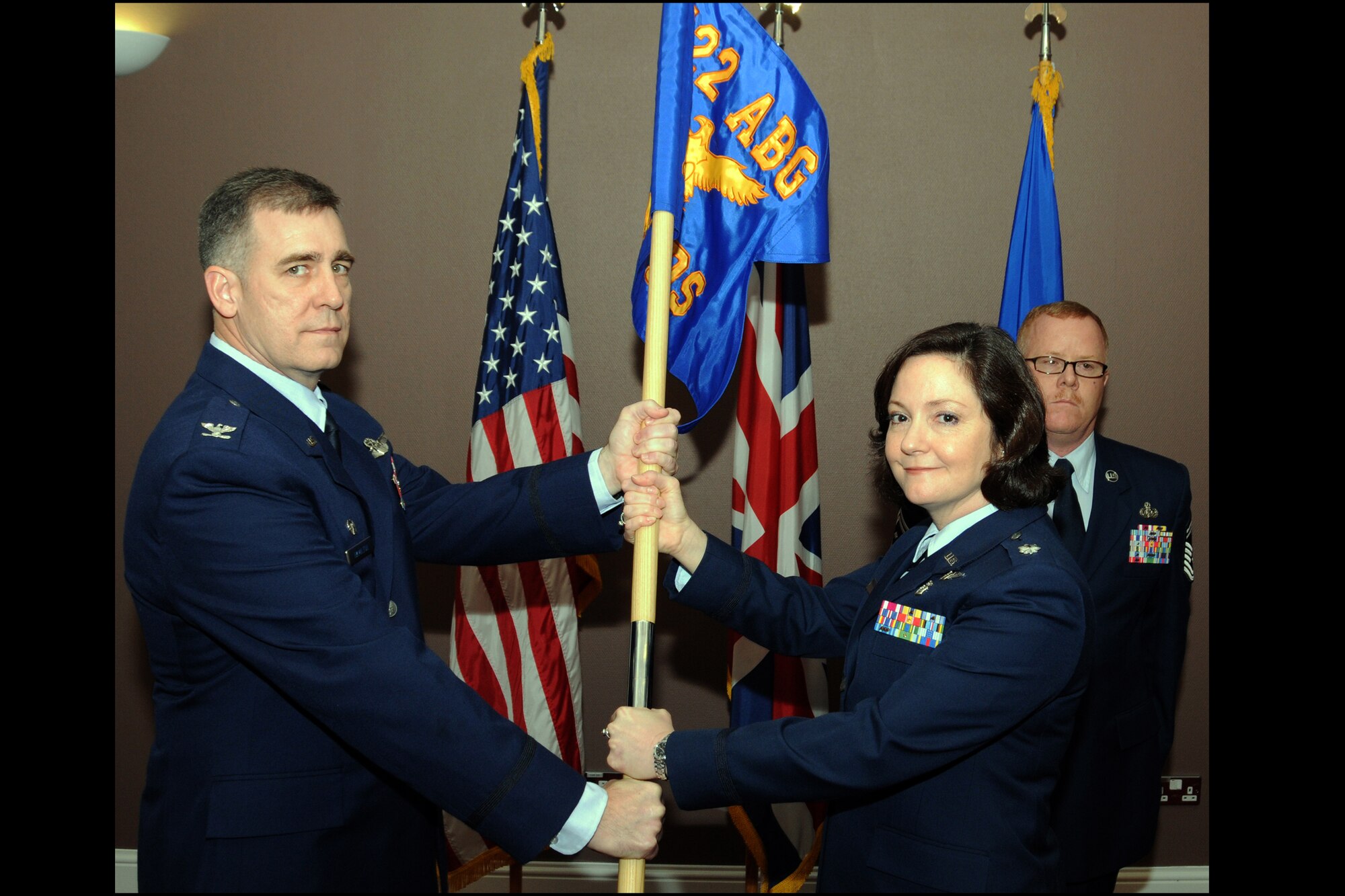 RAF CROUGHTON, United Kingdom - Lt. Col. Stephanie McCue accepts the 422nd Medical Squadron guidon from Col. Charles Hamilton, 422nd Air Base Group commander, during the 422nd MDS activation ceremony at the RAF Croughton Crown Nov. 28. McCue assumed command of the newly formed 422nd MDS, which takes it lineage from the U.S. Air Force Clinic Fairford, which was activated Aug. 1, 1981, and deactivated Sept. 1, 1988. (U.S. Air Force photo by Master Sgt. Randy Hillsgrove) 