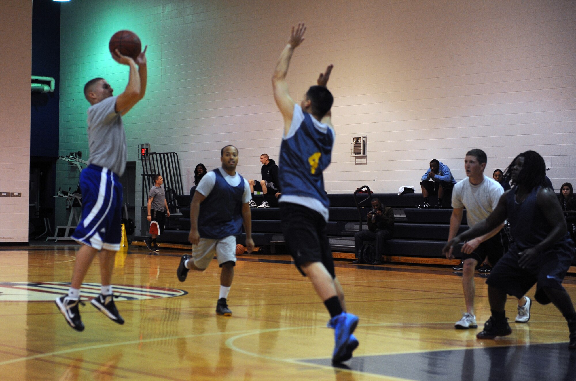 A member of the 23rd Fighter Group attempts a three-pointer over a 509th OSS player during the 509th OSS vs. 23rd FG intramural basketball season game Nov. 27 at Whiteman Air Force Base, Mo. The 23rd FG held a a 39-38 lead heading into the fourth quarter, but lost the game 60-49. (U.S. Air Force photo/Airman 1st Class Bryan Crane) (Released)