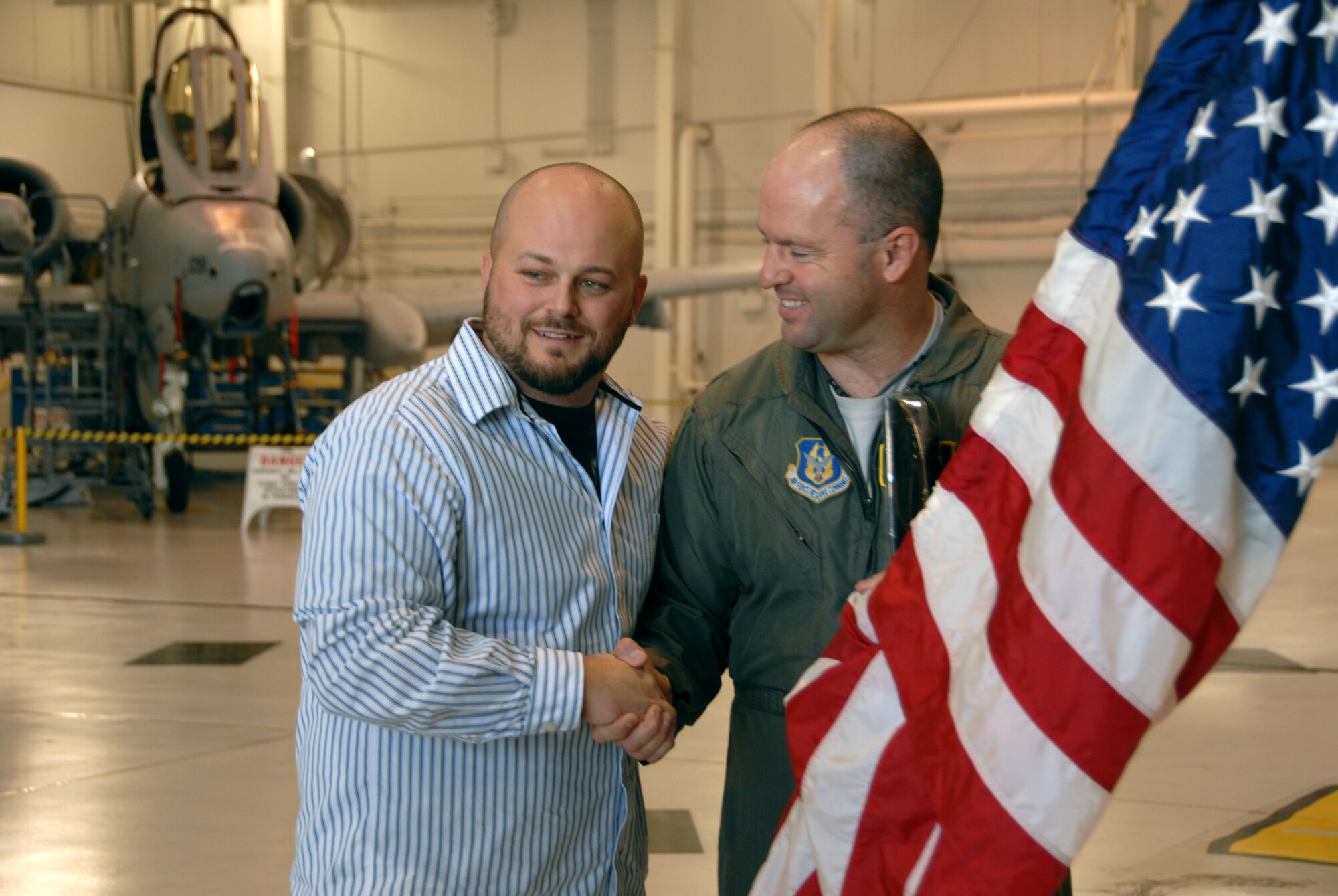 Derek Stephens, a soldier formerly assigned to the Kentucky National Guard, presents a flag flown in Afghanistan to Lt. Col. Anthony Roe, both A-10 Thunderbolt II pilots. Four soldiers visited the 442nd Fighter Wing, Nov. 17, 2012, to thank the pilots flying a mission in 2008 that saved their lives. The 442nd Fighter Wing is an Air Force Reserve unit at Whiteman Air Force Base, Mo. (U.S. Air Force photo by Staff Sgt. Lauren Padden/Released)