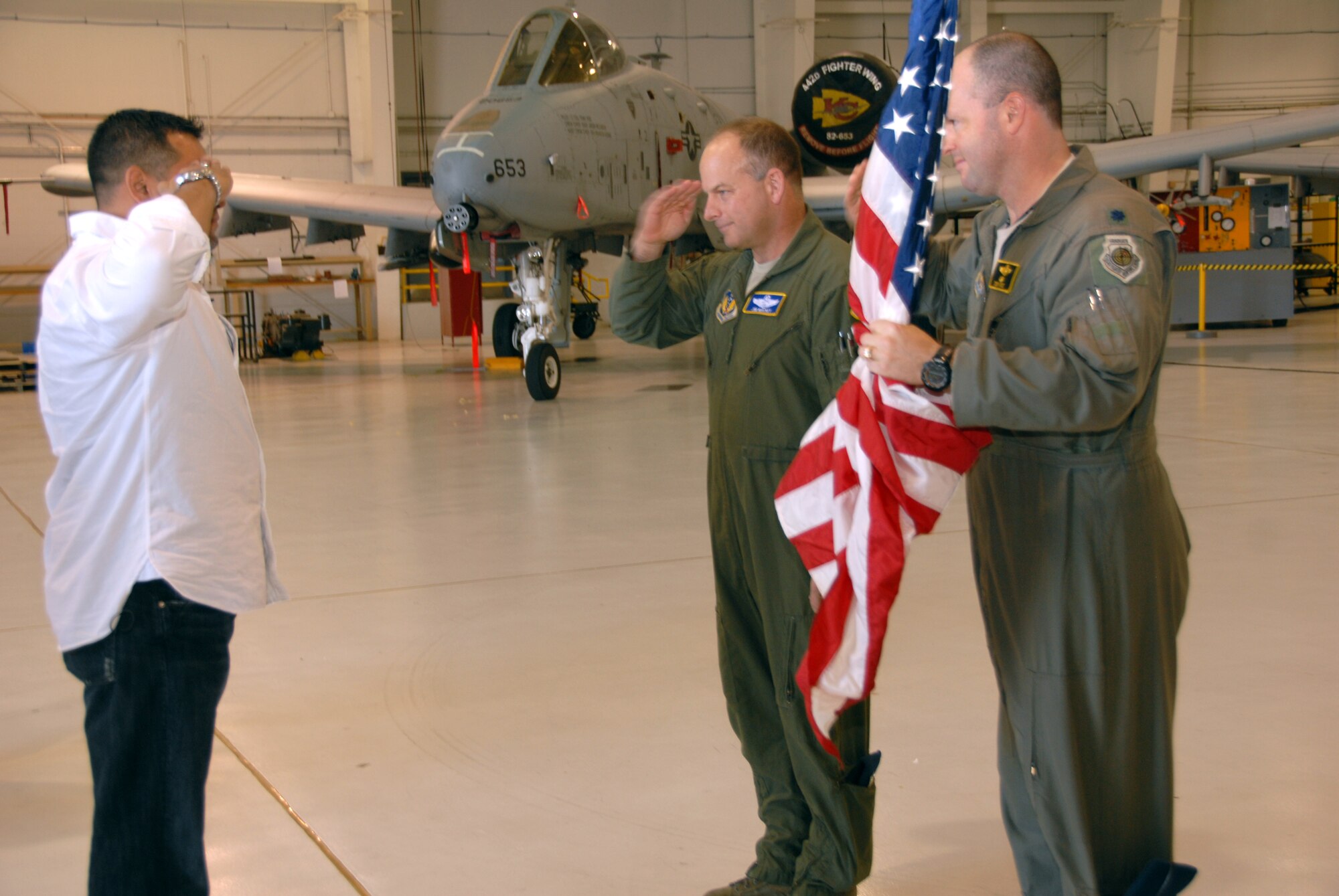 Army Sgt. Mauricio Arias, a soldier formerly assigned to the Kentucky National Guard, presents a flag flown in Afghanistan to Col. James Mackey and Lt. Col. Anthony Roe, both A-10 Thunderbolt II pilots. Four soldiers visited the 442nd Fighter Wing, Nov. 17, 2012, to thank the pilots flying a mission in 2008 that saved their lives. The 442nd Fighter Wing is an Air Force Reserve unit at Whiteman Air Force Base, Mo. (U.S. Air Force photo by Staff Sgt. Lauren Padden/Released)