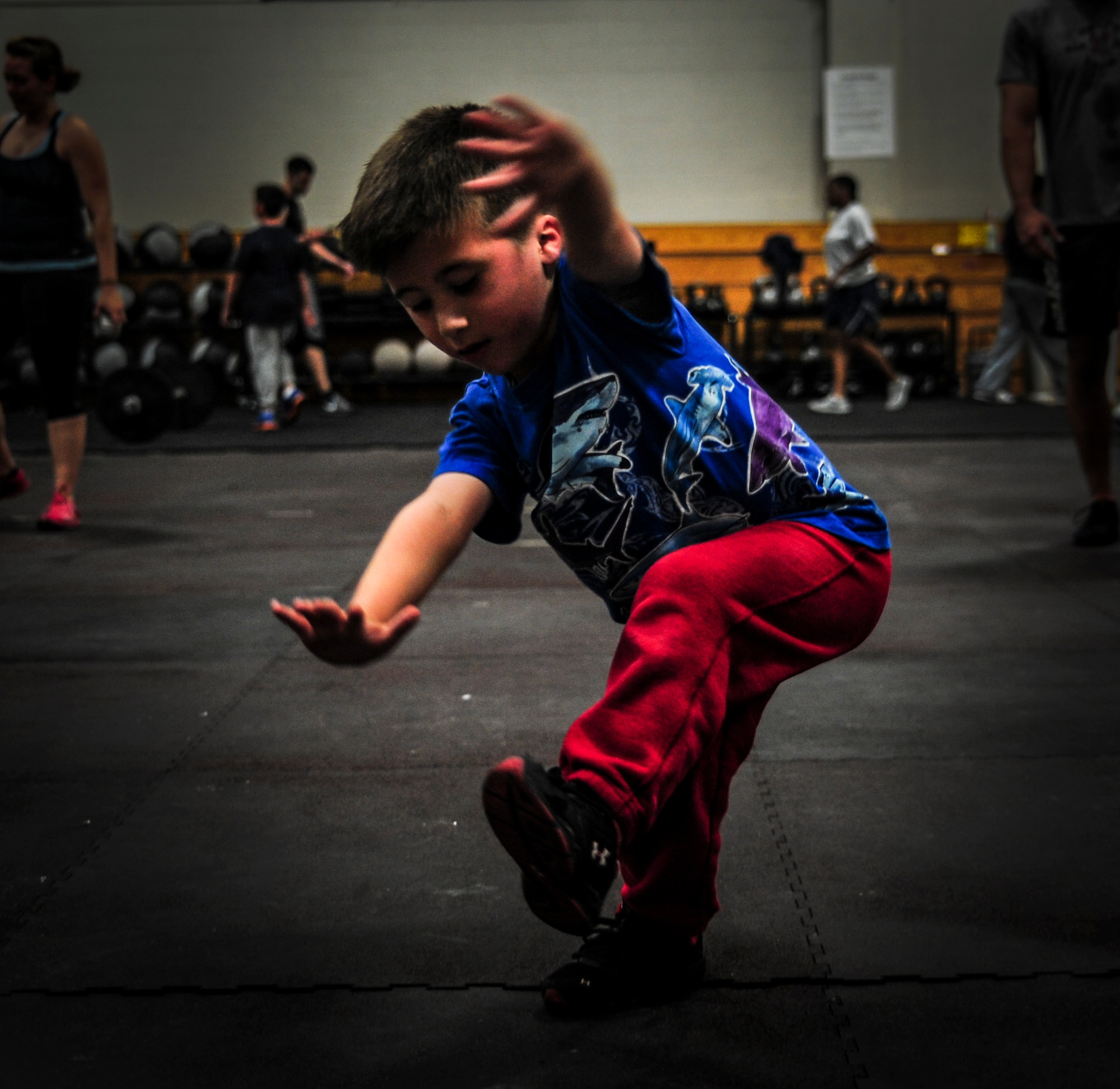 Six-year-old Alex Hart, son of Master Sgt. Steven Hart, 628th Security Forces Squadron first sergeant, performs a one-legged squat while his dad works out during a CrossFit class Nov. 19, 2012, at the Joint Base Charleston – Air Base gymnasium. (U.S. Air Force photo/ Senior Airman Dennis Sloan)