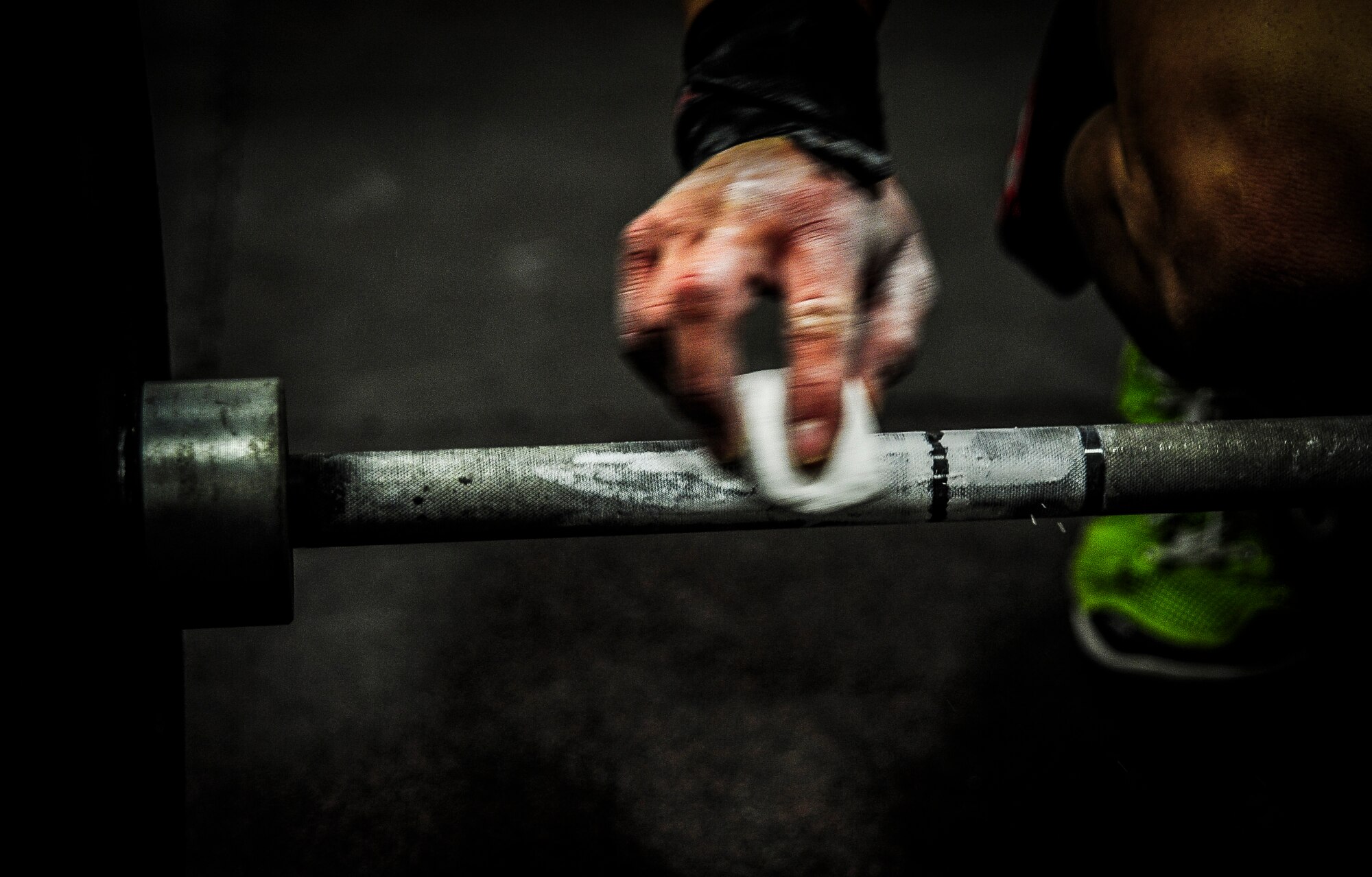 Chief Master Sgt. John Storms, 628th Security Forces Squadron superintendent, applies chalk to a bar during a CrossFit class Nov. 19, 2012, at the Joint Base Charleston – Air Base Fitness Center The CrossFit classes can accommodate individuals with different strength abilities and experience and there is always someone on hand to assist with proper form and technique. (U.S. Air Force photo/ Senior Airman Dennis Sloan)