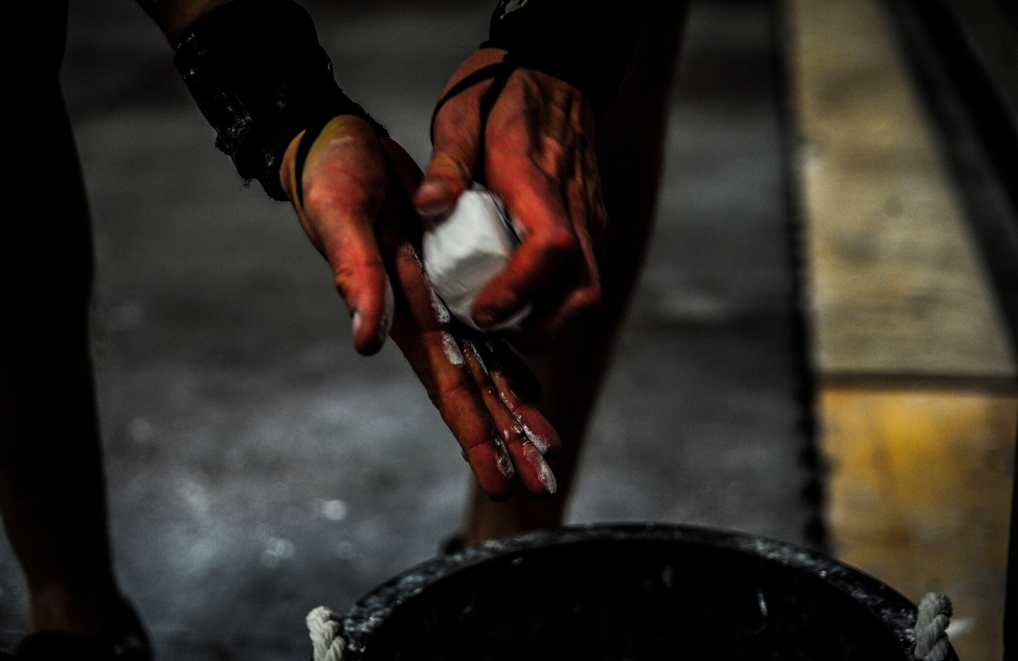 Chief Master Sgt. John Storms, 628th Security Forces Squadron superintendent, applies chalk to his hands to help him grip weights during a CrossFit class Nov. 19, 2012, at the Joint Base Charleston – Air Base Fitness Center. Several of the individuals at the CrossFit class use chalk, hand straps and tape when lifting weights. (U.S. Air Force photo/ Senior Airman Dennis Sloan)