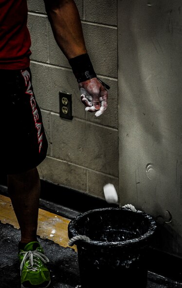 Chief Master Sgt. John Storms, 628th Security Forces Squadron superintendent, drops a piece of chalk into the chalk bucket after applying it to his hands to assist with grip when lifting weights during a CrossFit class Nov. 19, 2012, at the Joint Base Charleston, S.C., Fitness Center. Several of the individuals at the CrossFit class use chalk, hand straps and tape when lifting weights. (U.S. Air Force photo/ Senior Airman Dennis Sloan)