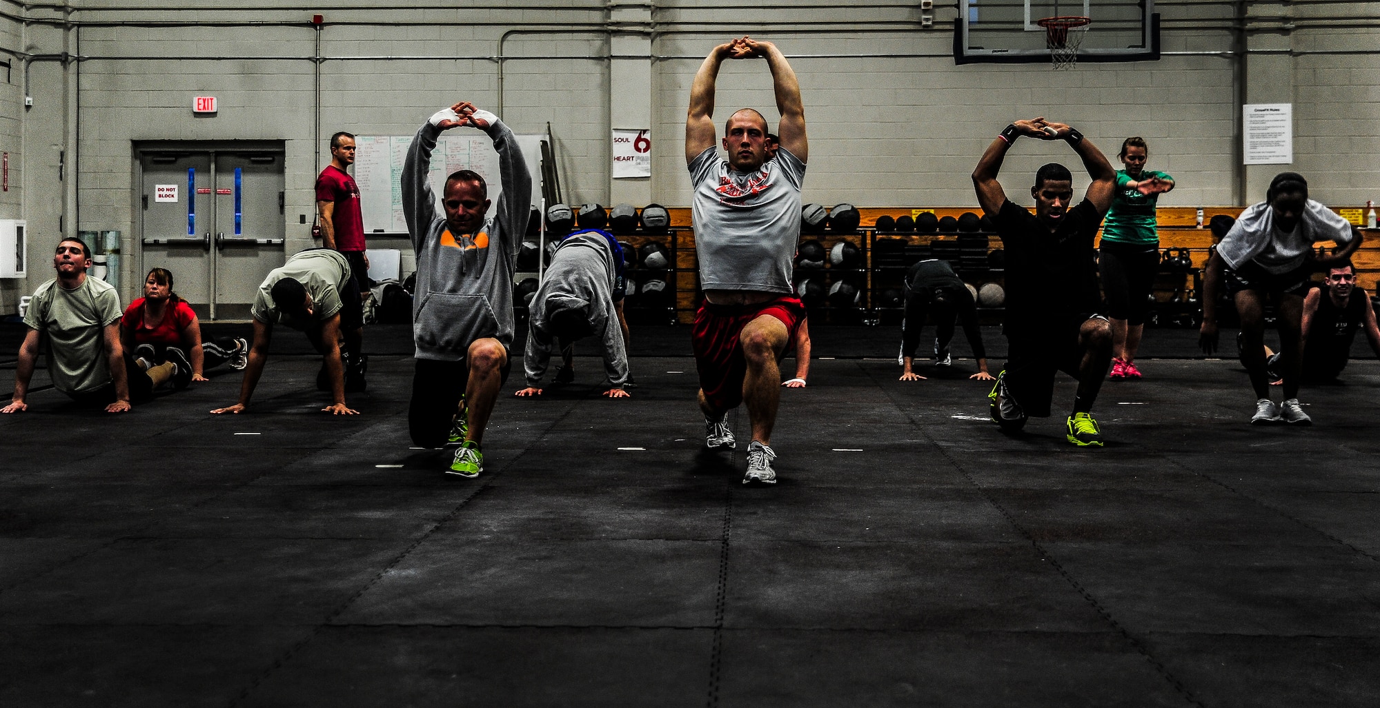 Service members and dependents stretch as a group before a CrossFit class Nov. 19, 2012, at the Joint Base Charleston – Air Base Fitness Center. The group conducts weightlifting, calisthenics and running during an hour-long workout session. The CrossFit classes are open to all military members, DoD employees and dependents. (U.S. Air Force photo/ Senior Airman Dennis Sloan)