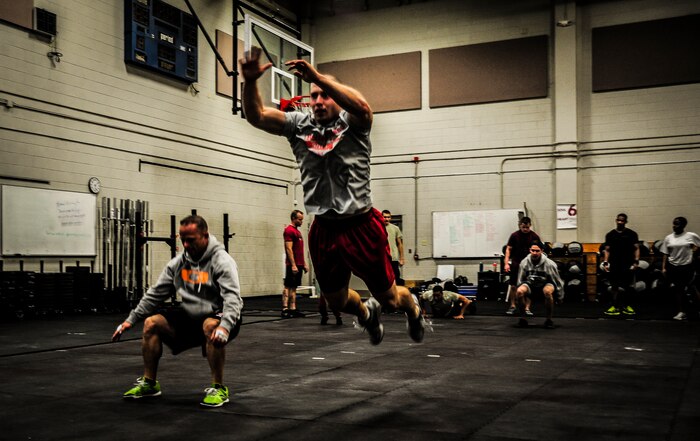 Senior Airman Joseph Schlank, 437th Aerial Port Squadron passenger terminal attendant, soars through the air ahead of Chief Master Sgt. John Storms, 628th Security Forces Squadron superintendent, while performing leap frogs to warm up before a CrossFit class Nov. 19, 2012, at the Joint Base Charleston – Air Base Fitness Center. CrossFit uses random physical challenges so each workout is varied and of high intensity. (U.S. Air Force photo/ Senior Airman Dennis Sloan)