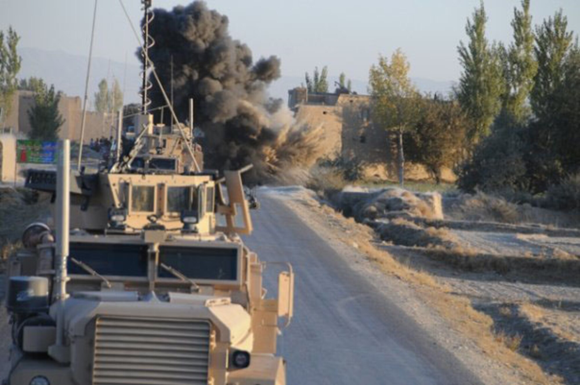 An improvised explosive device explodes near a U.S. convoy. Then-Tech. Sgt. Rebecca Corey  photographed events like this during her deployment to Afghanistan as a member of the provincial reconstruction teams working in the area. (U.S. Air Force photo)