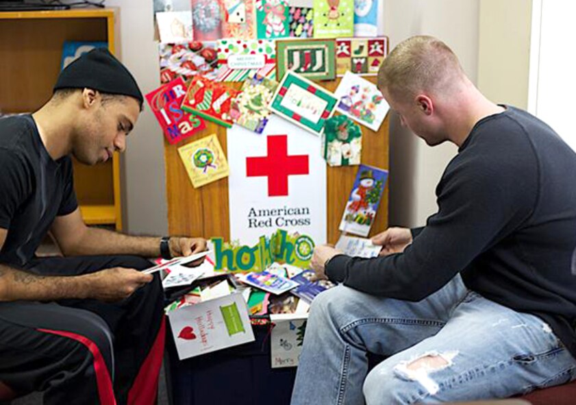 Marnell Dillingham, left, and Brandon Doty, American Red Cross Holiday Mail for Heroes Campaign volunteers, sort through holiday letters and cards at Misawa Air Base, Japan, Nov. 27, 2012. Forty-six volunteers helped sort through cards and letters that will be divided up and distributed to all units on base to be given to service members stationed at Misawa. (Courtesy photo)