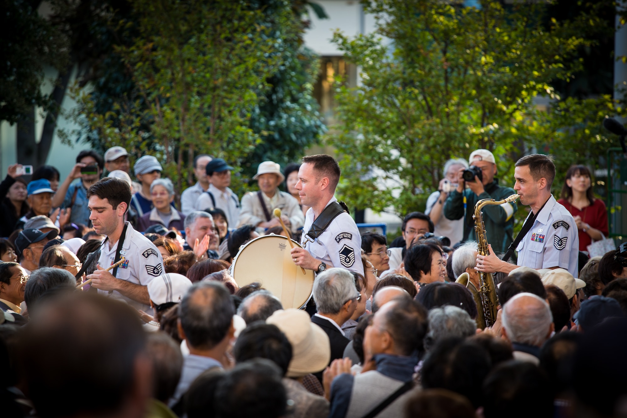 AKISHIMA, Japan -- Master Sgt. Jeremy Laukhuf, center, Band of the Pacific-Asia bassist, plays bass drum as Pacific Showcase, Band of the Pacific-Asia jazz ensemble, marches through the crowd on "When the Saints Go Marching In" at the Showa-no-Mori Music Festival, Akishima, Japan on Sept. 7, 2012. Many of the musicians have the ability to play multiple musical instruments in the group. (U.S. Air Force photo/Staff Sgt. Josh Voyles)