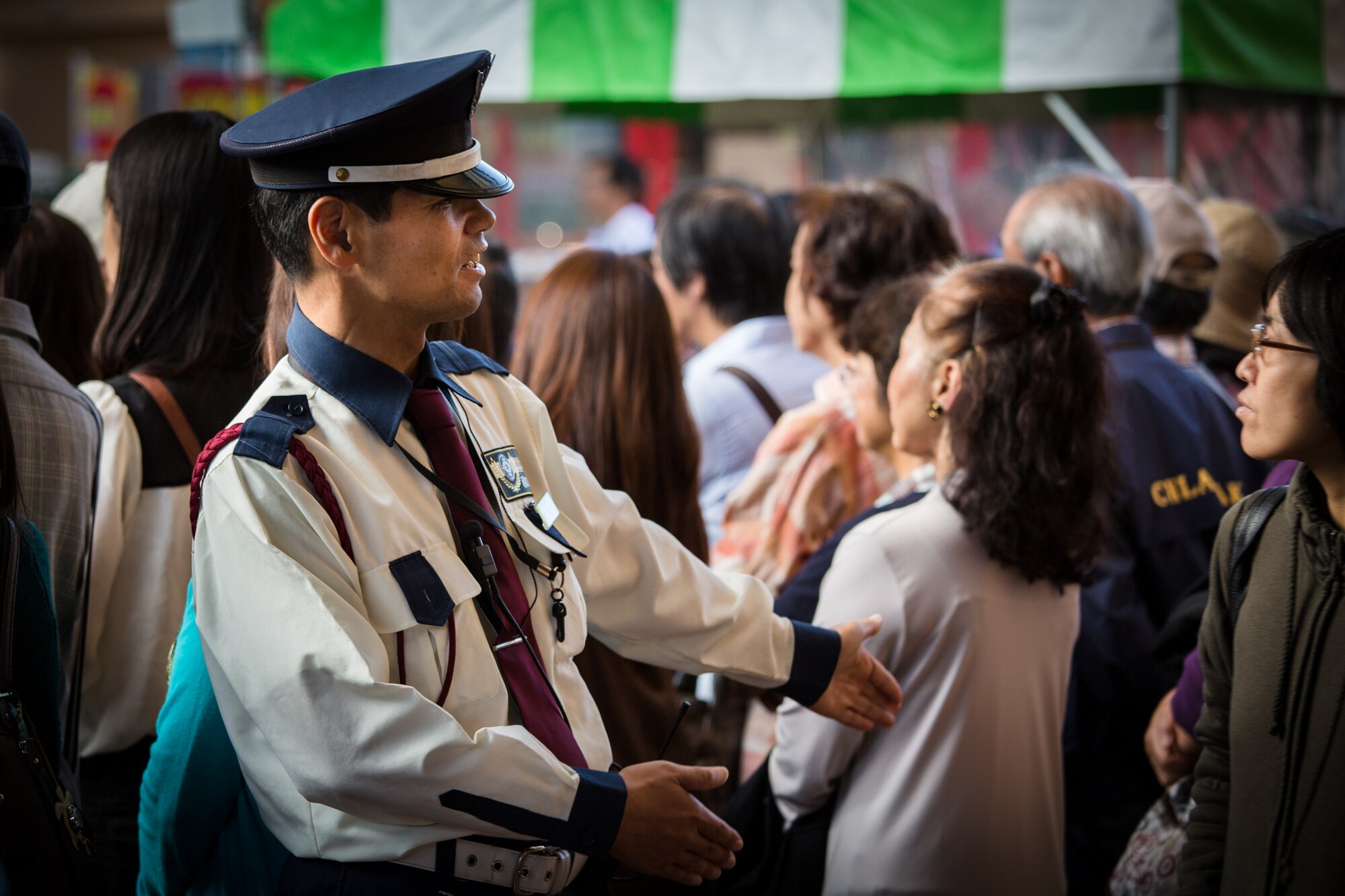 AKISHIMA, Japan -- A local security officer guides passers-by through the large crowd watching Pacific Showcase, Band of the Pacific-Asia jazz ensemble, perform at the Showa-no-Mori Music Festival, Akishima, Japan on Sept. 7, 2012. Approximately 2500 people were in attendance. (U.S. Air Force photo/Staff Sgt. Josh Voyles)