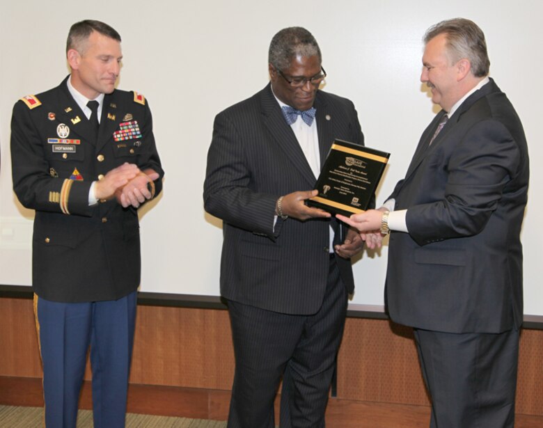 John L. Robinson, principal and owner of Strategic Value Solutions, Inc., presents Kansas City Mayor Sly James and Col. Anthony J. Hofmann, commander of the Kansas City District U.S. Army Corps of Engineers, with the Alphonse J. Dell'Isola Award for Outstanding Accomplishment in Construction on behalf of SAVE International during a presentation held Nov. 28, 2012. SVS, Inc. submitted the Blue River Channel Modification Project for the award. The redesigned project saved taxpayers approximately $35 million. U.S. Army Corps of Engineers photo by Rusty Thomas.