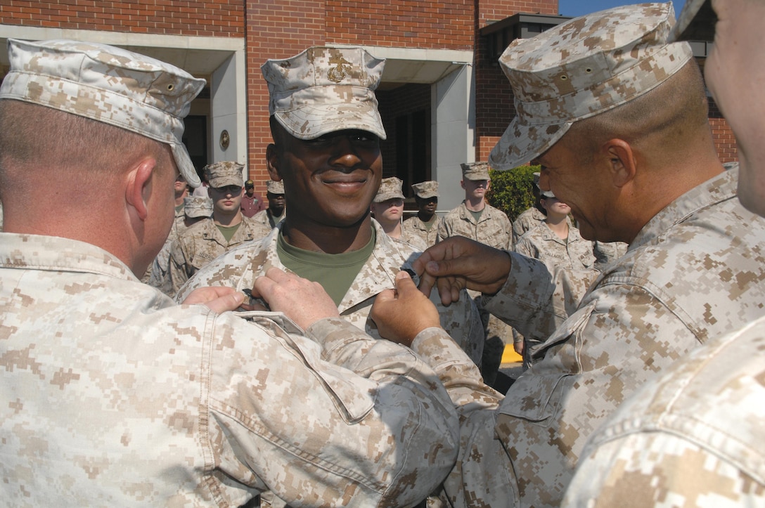 Sgt. Aspen Thompson has his new sergeant chevrons pinned on by Sgt. Deryl Stockton, left, and Master Sgt. Mark Carabello, right, all with Military Operations and Training Branch, Operations and Training Division, Marine Corps Logistics Base Albany, Nov. 2.