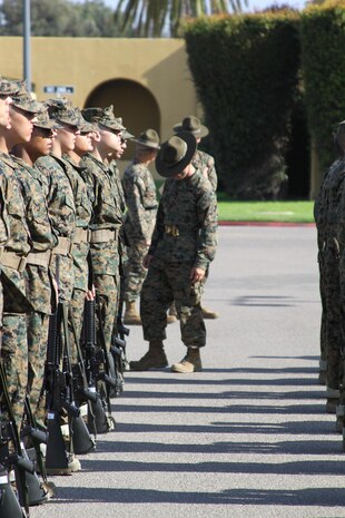 A drill instructor with Company A, 1st Recruit Training Battalion, checks the alignment of each squad in his platoon. Cover and alignment is important because it allows the platoon to move one in an orderly fashion.