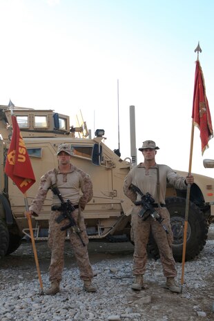 Sergeant William Whetzel, left, squad leader, Fox Company, 2nd Battalion, 7th Marines, Regimental Combat Team 7, holds the company’s standard guidon while Sgt. Erik Frederiksen, squad leader, Fox Co., holds the guidon paying tribute to the Marines who came before them.