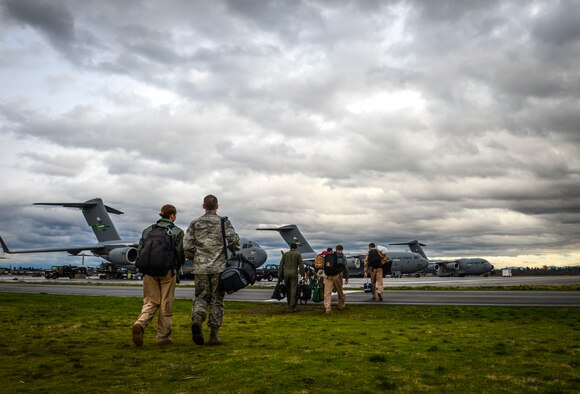 Airmen from the 10th Airlift Squadron walk across the airfield to a C-17 Globemaster III to depart for their deployment, Nov. 29, 2012, at Joint Base Lewis-McChord, Wash. During the scheduled 2-month deployment, the Airmen will operate out of two bases, managing and flying missions concentrated in and around Afghanistan, Iraq and the Horn of Africa. (U.S. Air Force photo/Staff Sgt. Sean Tobin)