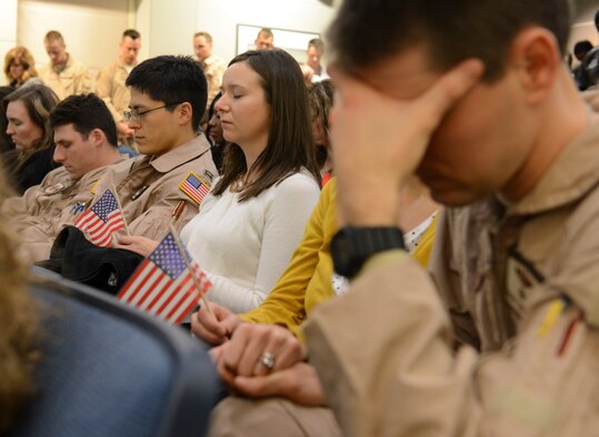 Airmen from the 10th Airlift Squadron and their family members pause to reflect during the invocation prior to a deployment briefing, Nov. 29, 2012, at Joint Base Lewis-McChord, Wash. This deployment, in support of Operation Enduring Freedom, was the second deployment this year for the 10th AS. (U.S. Air Force photo/Staff Sgt. Sean Tobin)