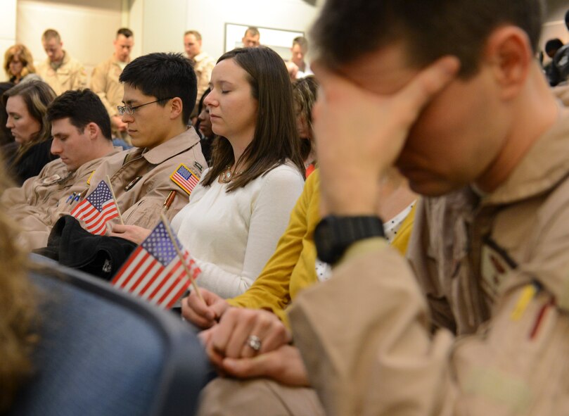 Airmen from the 10th Airlift Squadron and their family members pause to reflect during the invocation prior to a deployment briefing, Nov. 29, 2012, at Joint Base Lewis-McChord, Wash. This deployment, in support of Operation Enduring Freedom, was the second deployment this year for the 10th AS. (U.S. Air Force photo/Staff Sgt. Sean Tobin)