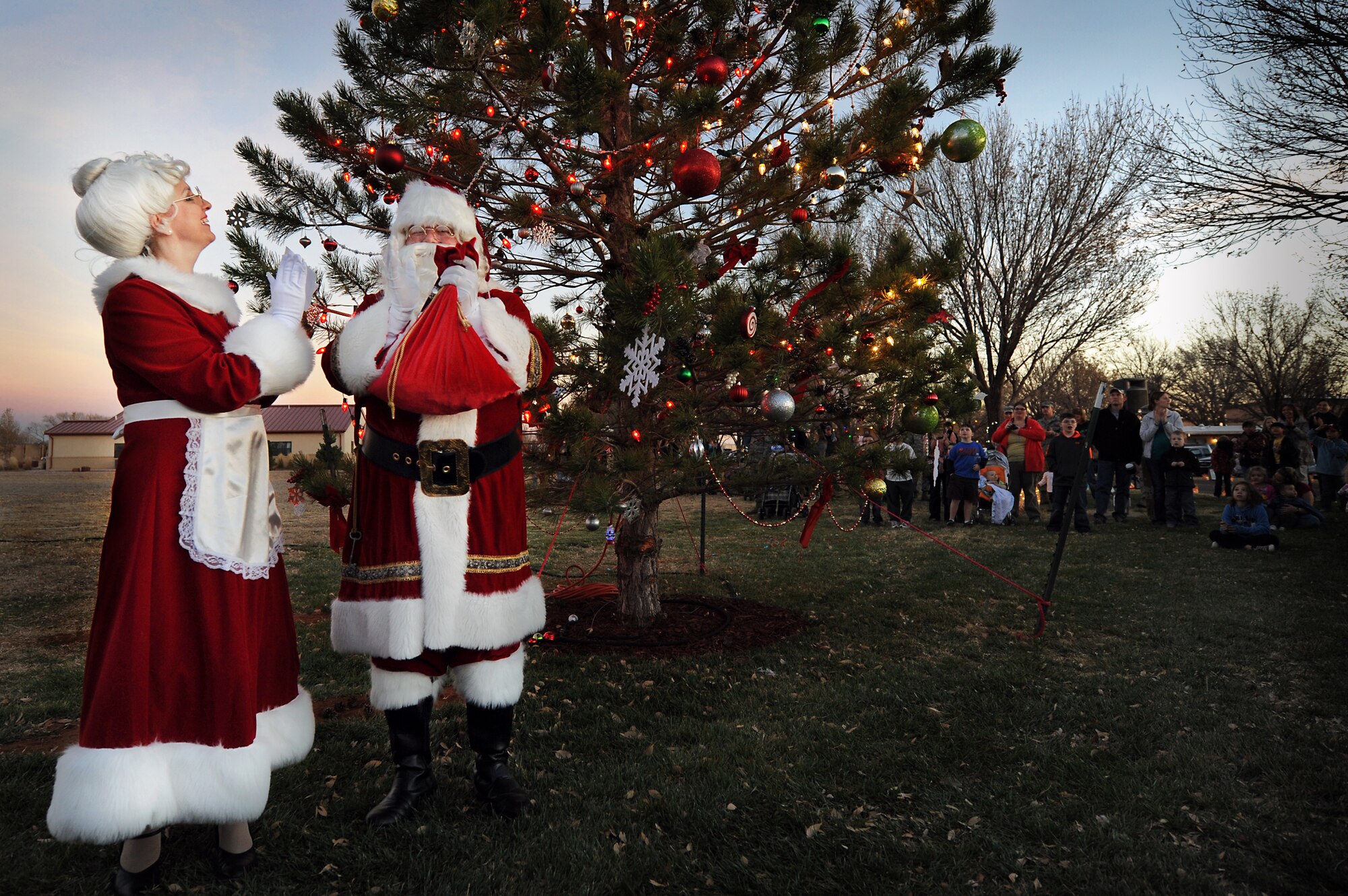 Santa and Mrs. Claus applaud as a tree is lit during a ceremony at Cannon Air Force Base, N.M., Nov. 29, 2012.  The tree lighting ceremony and holiday parade are annual events taking place each year to kick-off the holiday season.  (U.S. Air Force photo/Senior Airman Jette Carr)