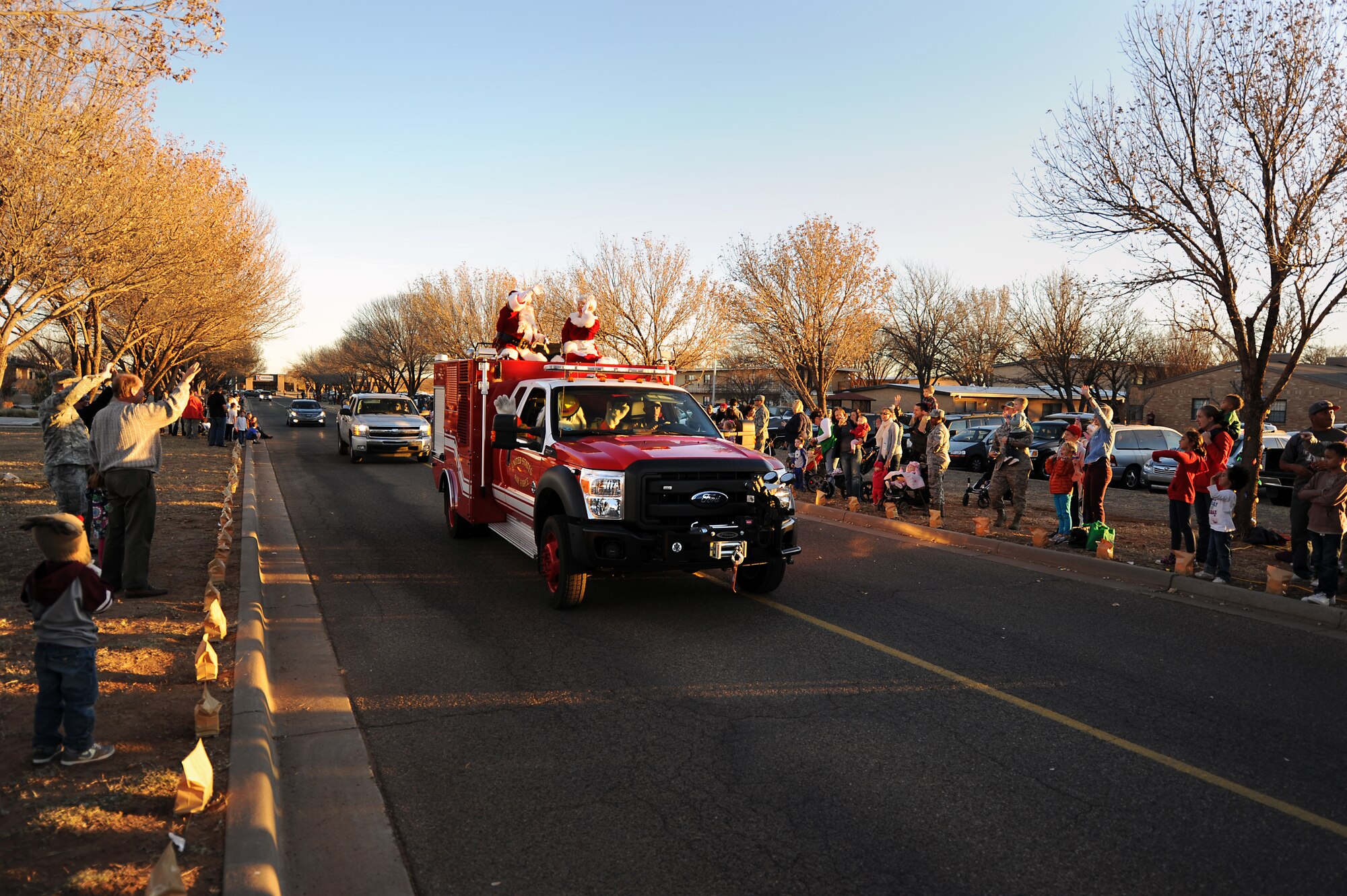 Crowds wave to Santa and Mrs. Claus during the annual holiday parade and tree lighting ceremony at Cannon Air Force Base, N.M., Nov. 29, 2012.  This festive event takes place each year as a kick-off to the holiday season.  (U.S. Air Force photo/Senior Airman Jette Carr)